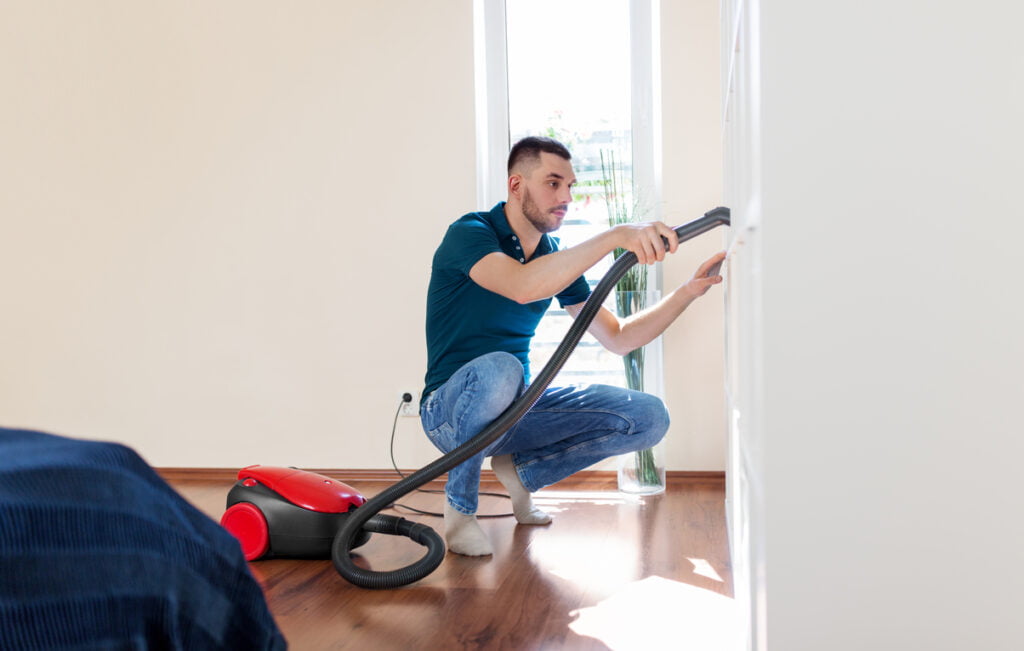 man with vacuum cleaner at home