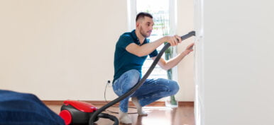 man with vacuum cleaner at home