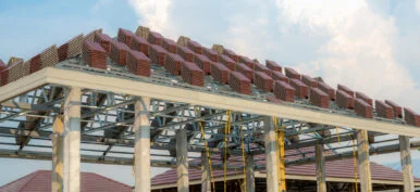 A roof under construction with stacks of roof tiles for home building