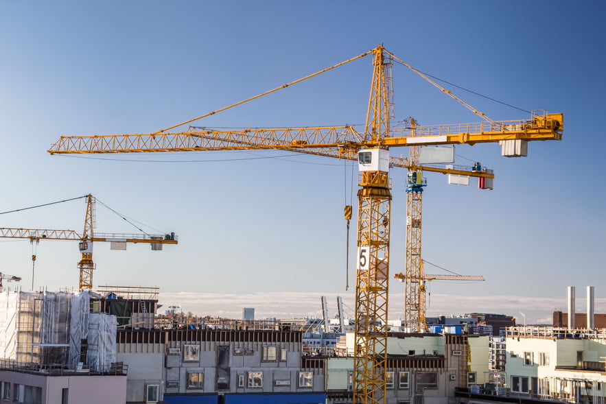 Construction site with tower cranes against clear sky.