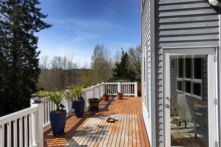 Home outdoor cedar wood deck boards being stained with materials
