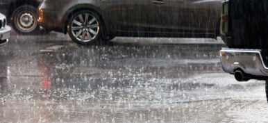 Large drops of heavy rain on a city road.