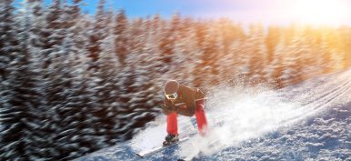 Skier in helmet and glasses racing from mountain