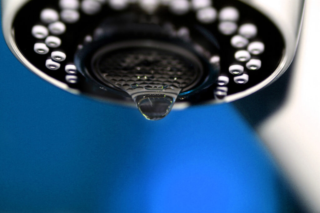 A macro of a white tap / faucet dripping.
